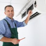Young Repairman Repairing Ceiling Air Conditioning Unit Stock Photo ...
