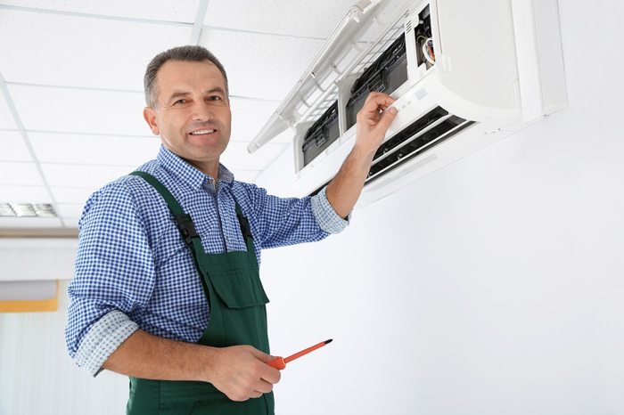 Young Repairman Repairing Ceiling Air Conditioning Unit Stock Photo ... Young Repairman Repairing Ceiling Air Conditioning Unit Stock Photo ...